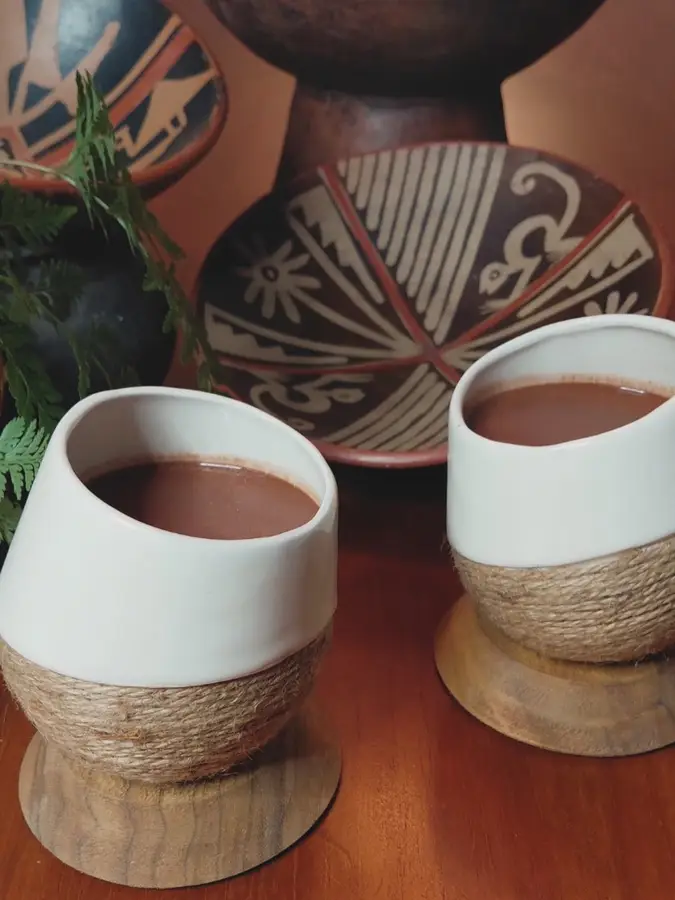 Two cups of cacao in woven wooden holders